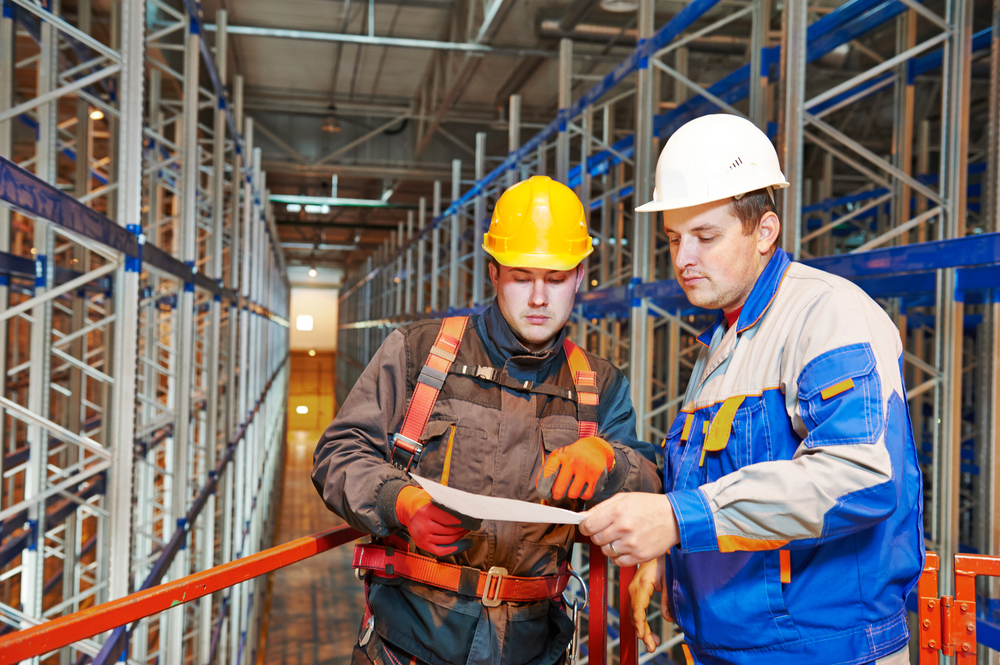 Two,Warehouse,Worker,In,Front,Of,Rack,Stack,In,Storehouse